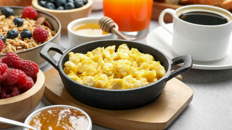 A cast iron skillet full of scrambled eggs.