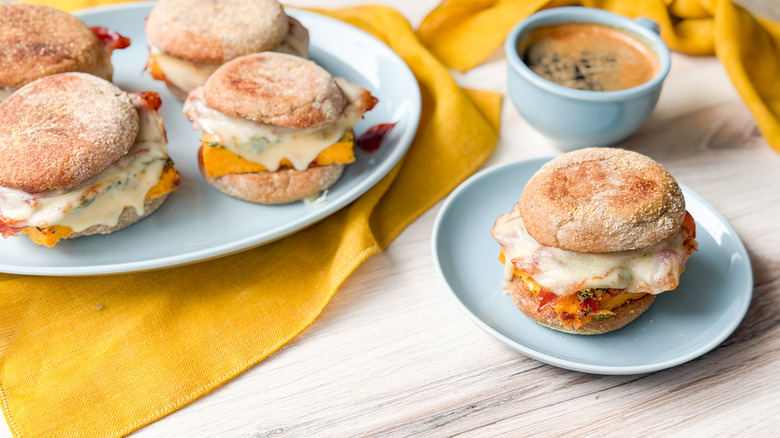 High-protein English muffin breakfast sandwiches on platter and plate with coffee cup