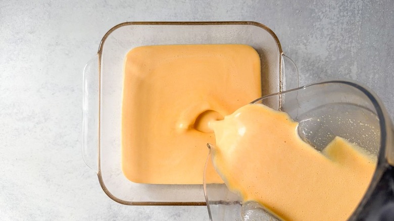 Pouring egg filling ingredients into oiled, square baking dish