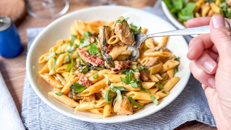 High protein marry me chicken pasta on serving plate with forkful