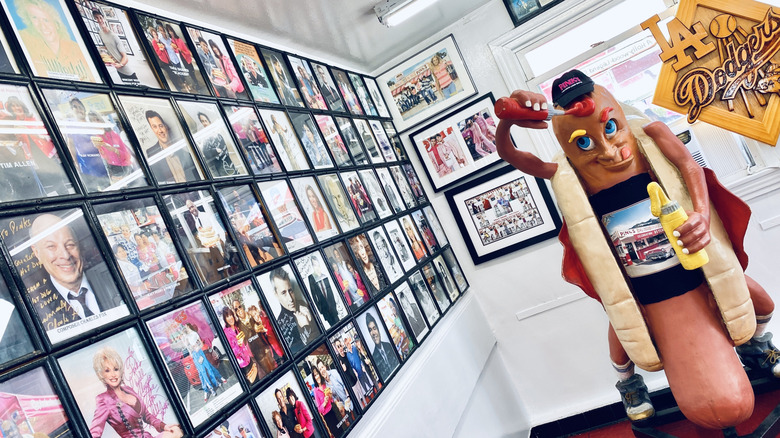 Wall of celebrity headshots and hot dog character at Pink's Hot Dogs
