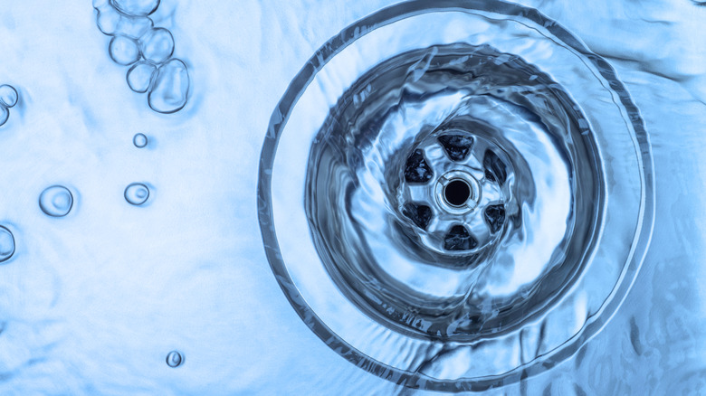 Running hot water down the kitchen sink.