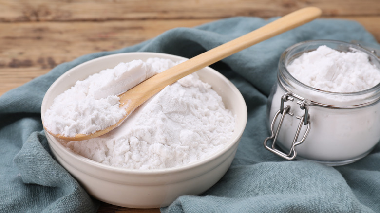 Flour or cornstarch in clear glass with a spoon