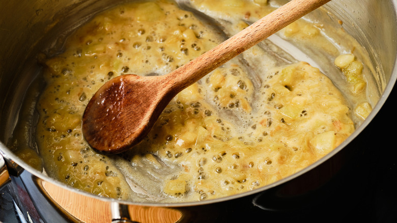 Cooking roux in a pot with a wooden spoon
