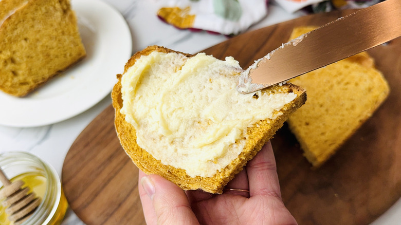 Spreading honey butter on pumpkin toast