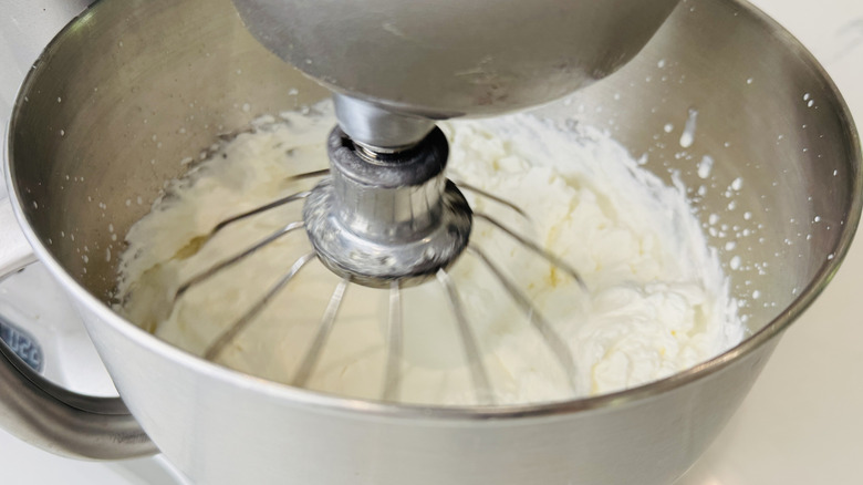 Whipped cream in mixing bowl with whisk