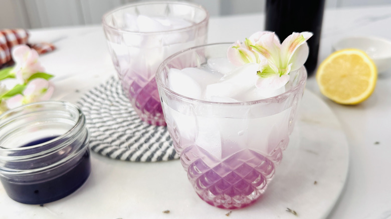 Glasses filled with liquid and lavender syrup