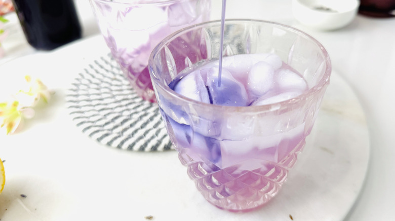 Pouring lavender syrup into beverage