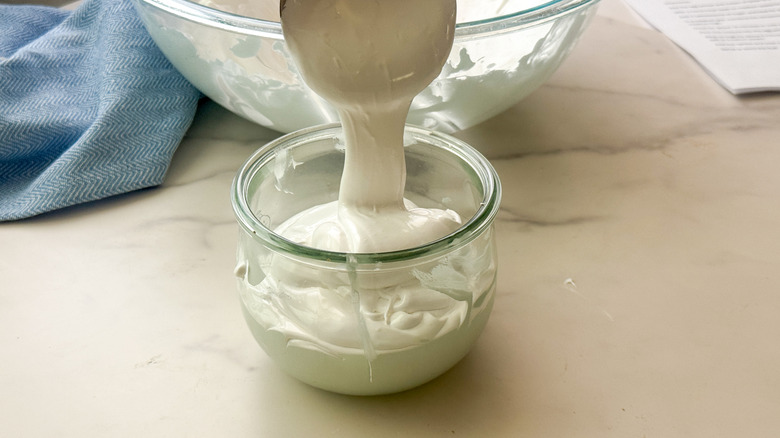 ladle of fluff pouring into jar