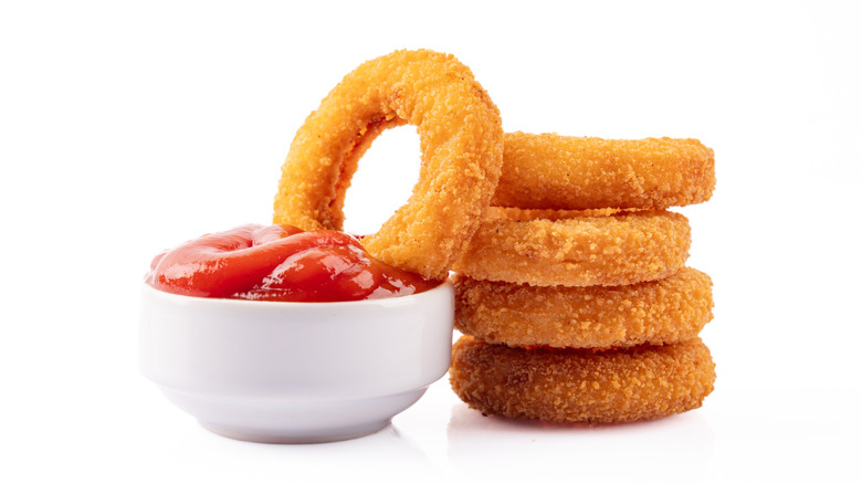 onion rings next to a bowl of ketchup