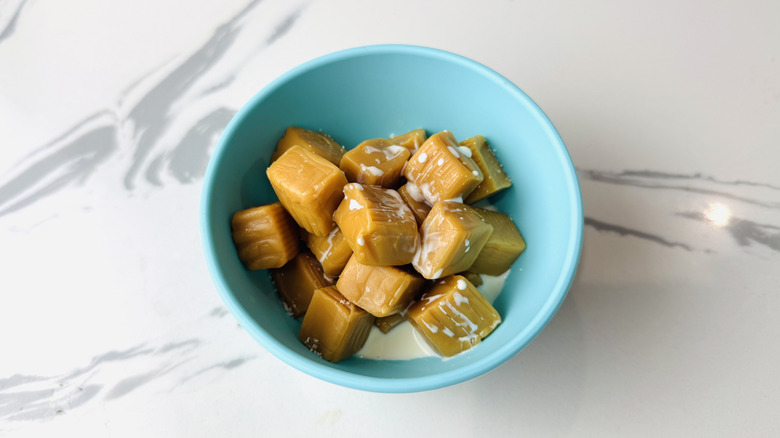 Caramels and heavy cream in microwave-safe bowl