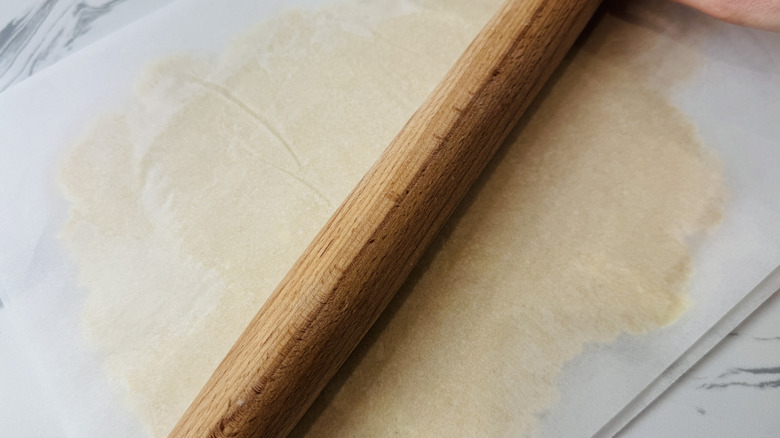 Dough rolled out between parchment paper