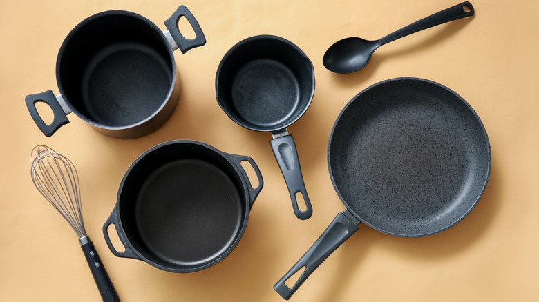 Pots, pans, and utensils overhead on a beige background