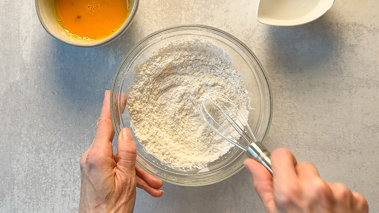 Whisking cornstarch and seasonings in bowl on counter top