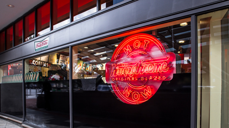 The red neon sign reading, "Krispy Kreme ORIGINAL GLAZED HOT NOW" is lit up at the bakery's Dupont Circle location in Washington, D.C.