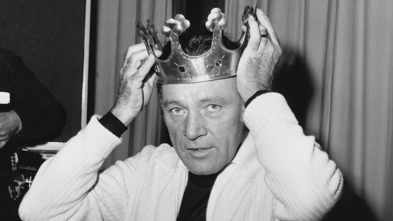 Richard Burton places a crown on his head