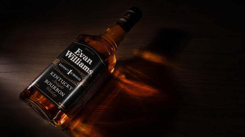 Bottle of Evan Williams bourbon on dark wood counter.