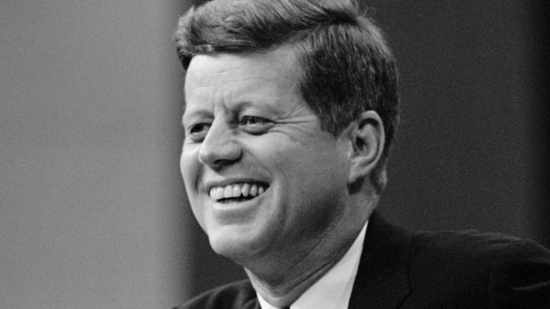 John F. Kennedy smiling in black and white photo