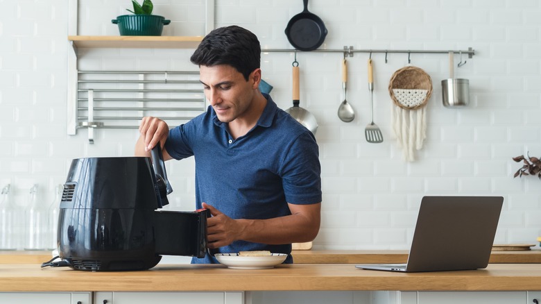 Person cooking with air fryer