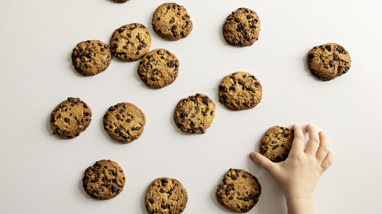chocolate chip cookies with a hand reaching for one
