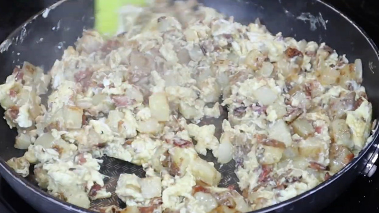 A close up of a recreation of the homestead breakfast made up of bacon, potatoes, and eggs