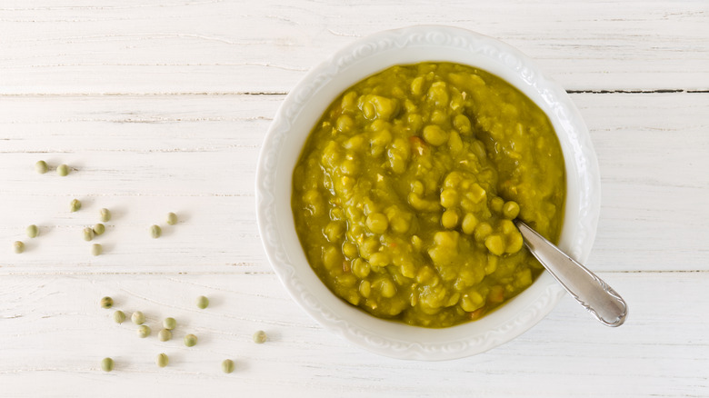 A bowl of split pea soup against a white background