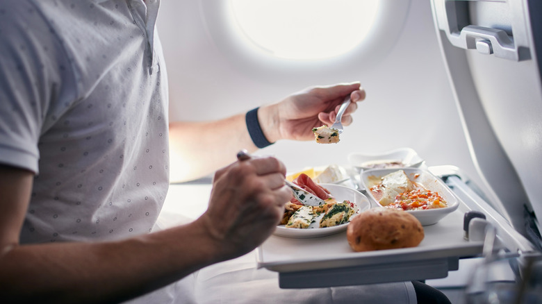 Passenger eating a meal on a plane