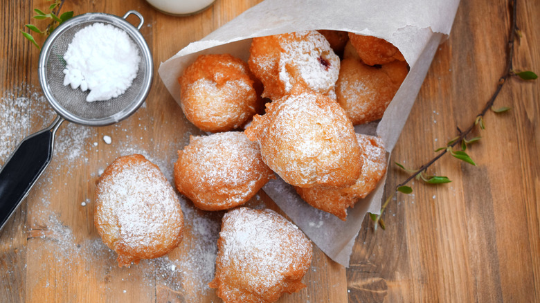 Beignets in a paper cone dusted with powdered sugar