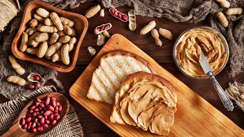Peanuts, peanut butter, and toast on a table