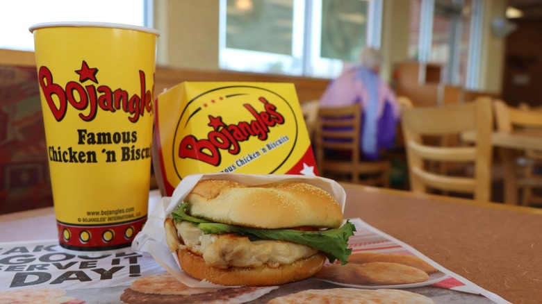 Bojangles cup, takeout container, and chicken sandwich on a table