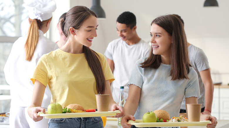Students with trays in dining hall