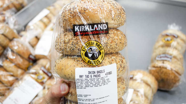 Person holding a bag of Kirkland Signature Einstein Bros. Bagels onionbagels