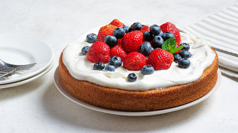 A sponge cake with frosting and berries