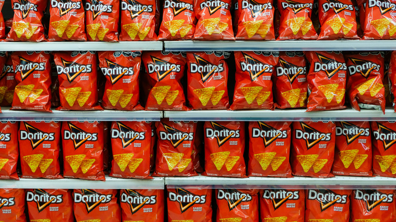Grocery store shelves filled with red bags of Doritos chips