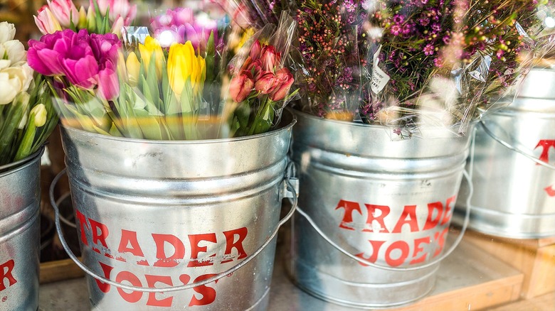 Colorful flowers in silver buckets with red Trader Joe's logo