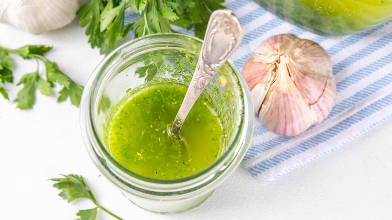 Herb-infused salad dressing with garlic on side