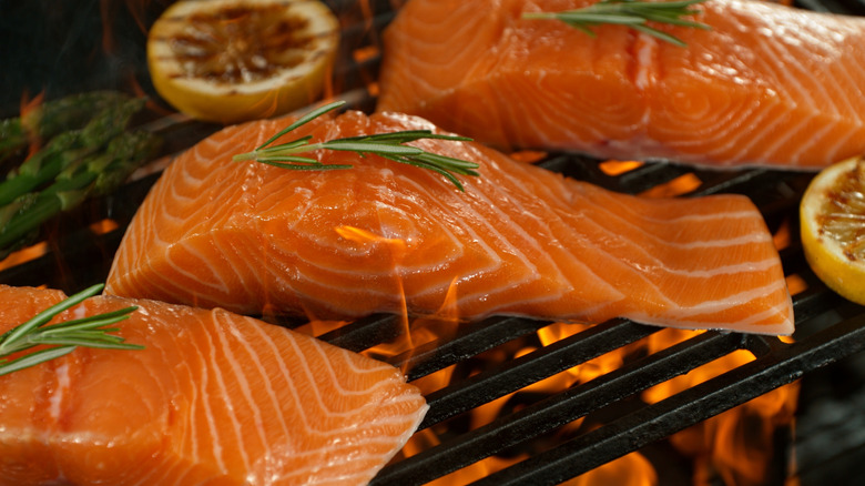 fish on grill grates with fresh herbs on top