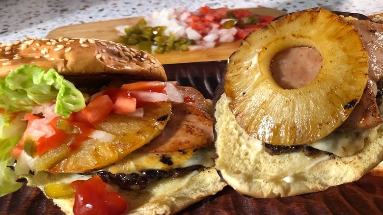 An open-faced Mexican burger, featuring ham, pineapple, and other toppings