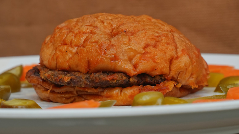 An islak burger on a plate with pickled vegetables