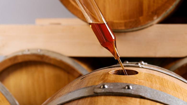 distiller sampling Irish whiskey from a barrel