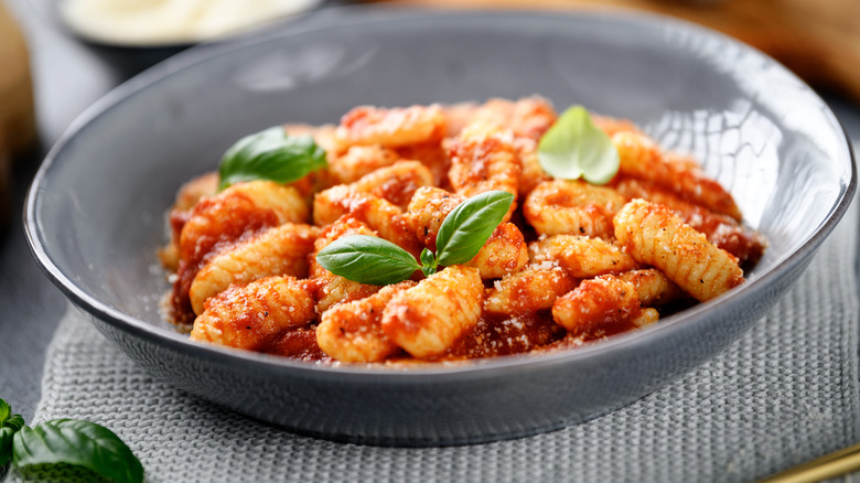 Traditional Italian potato gnocchi with tomato sauce, parmesan cheese and fresh basil leaves