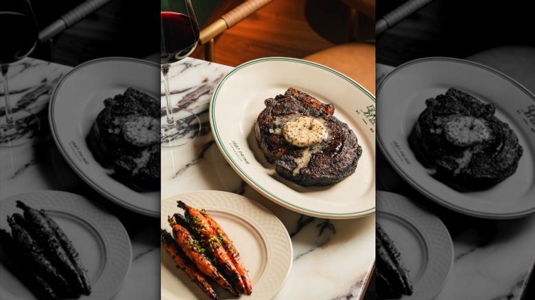 A boneless ribeye steak and carrots at 1587 prime