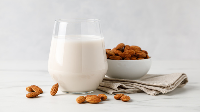 Glass of almond milk next to almonds