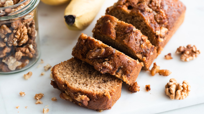 Homemade banana bread with walnuts cut into slices, closeup view