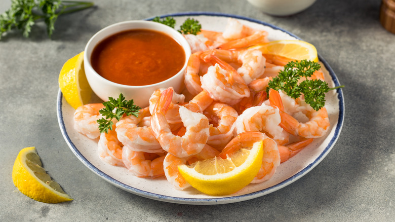 Cooked shrimp on a plate with cocktail sauce