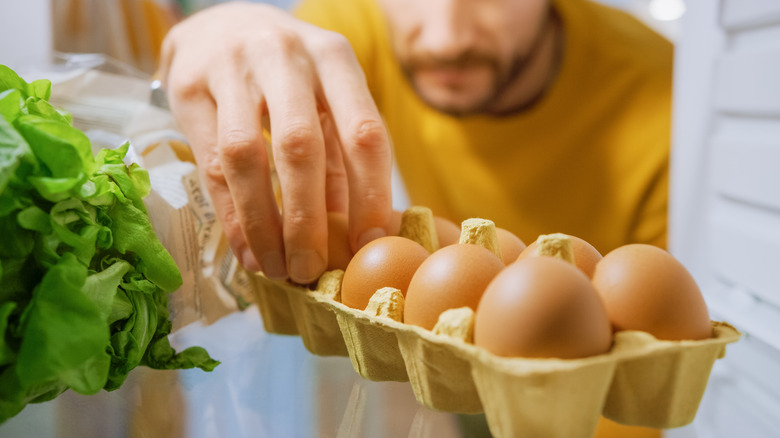 grabbing eggs from refrigerator