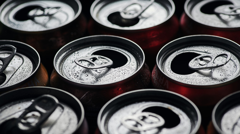 an array of soda cans, all open