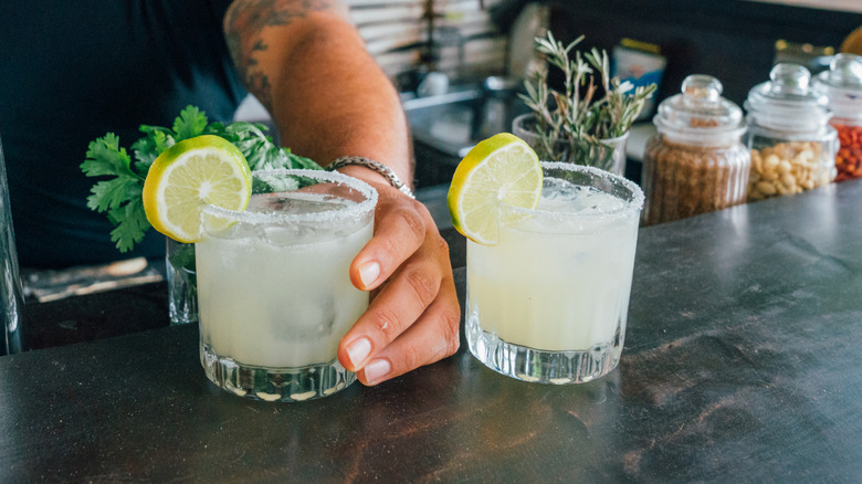 a bartender with two margaritas