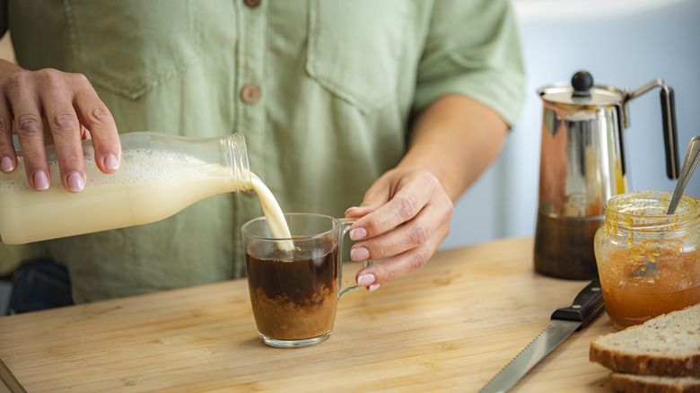 oat milk being poured into coffee