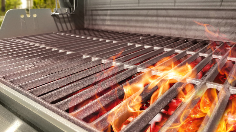 Barbecue grill with flames shooting up through grill grates